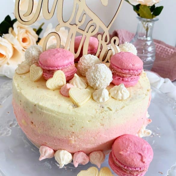 Kokos-Himbeer-Torte, dekoriert mit Macarons und Caketopper