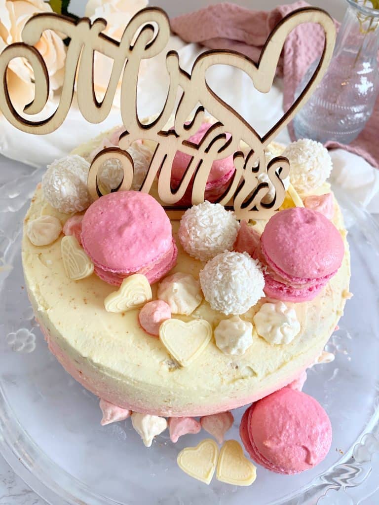 Kokos-Himbeer-Torte, dekoriert mit Macarons und Caketopper