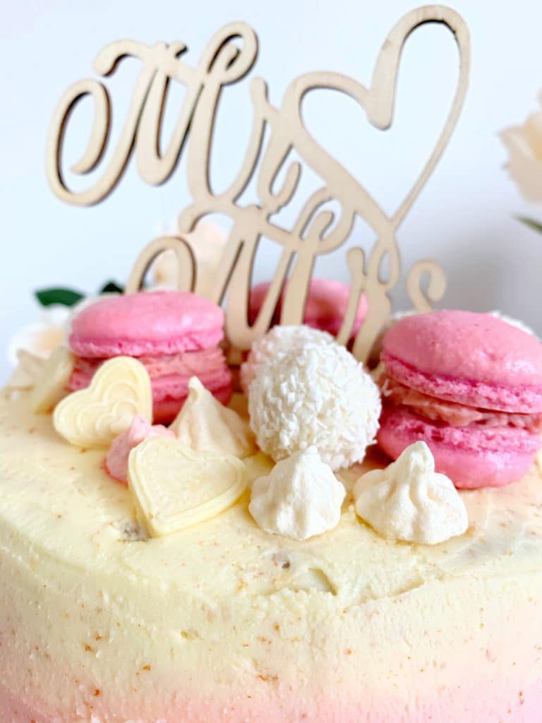 Kokos-Himbeer-Torte, dekoriert mit Macarons und Caketopper