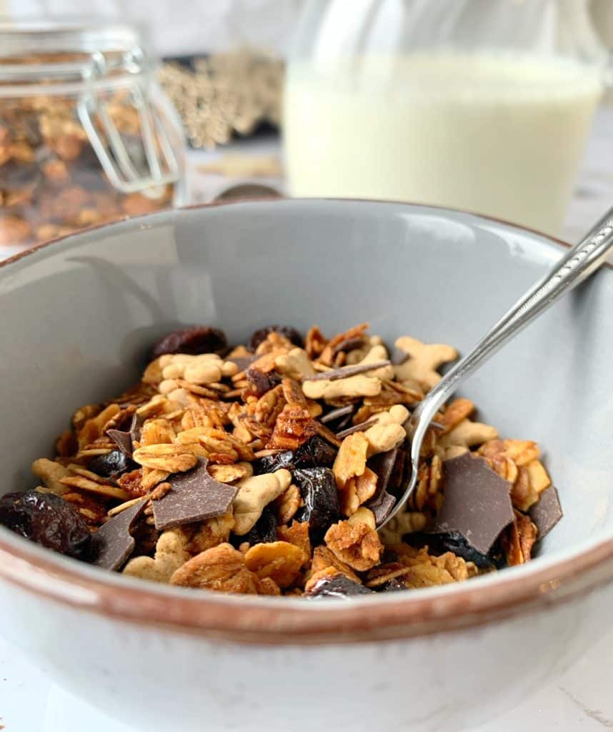 Granola in Schüssel mit Milch im Hintergrund