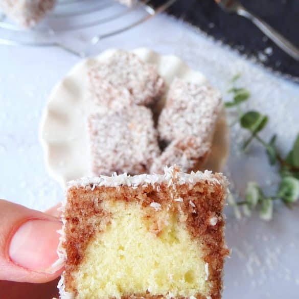 Lamingtons angeschnitten mit den Fingern angehoben