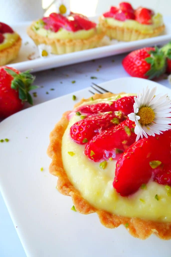 Erdbeer-Pistazien-Tartelettes mit Gänseblümchen dekoriert